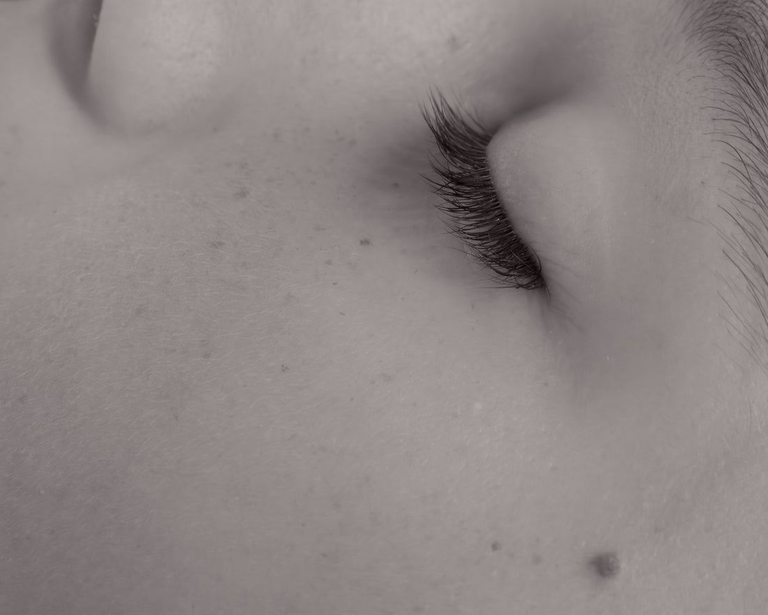 Close-up of a sleeping baby's closed eye and eyelashes.